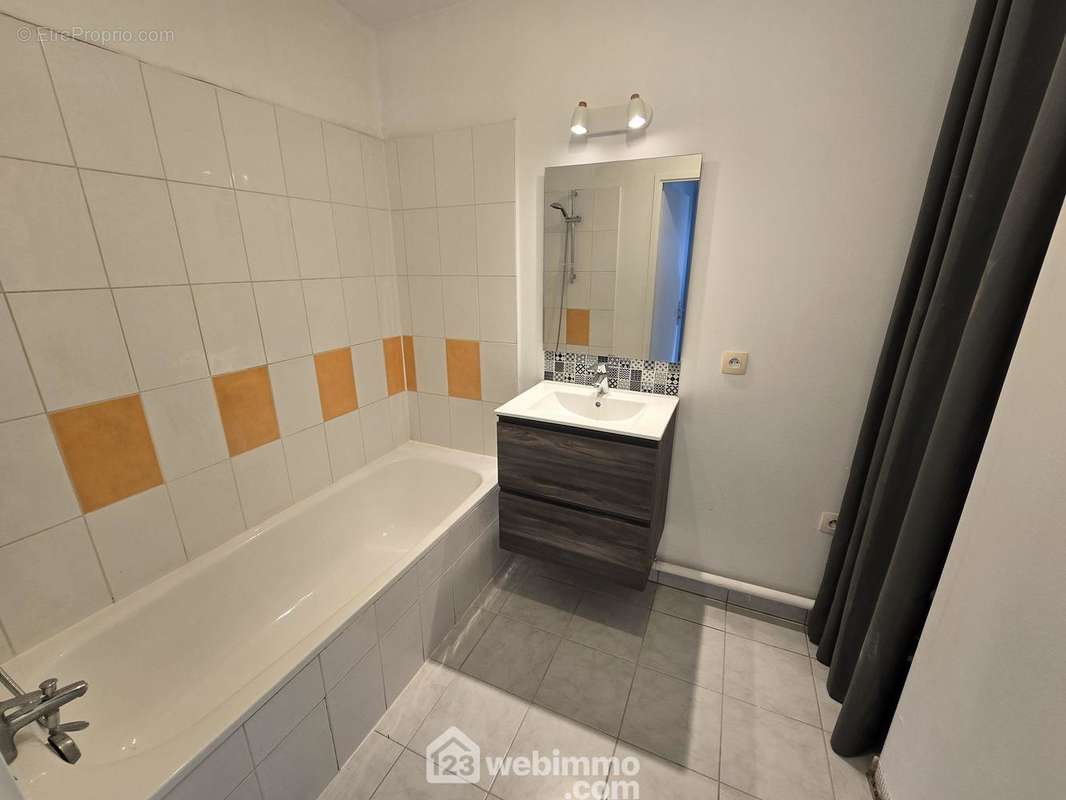 Une salle de bain avec baignoire, les WC sont séparés - Appartement à BORDEAUX