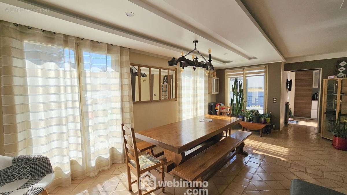 Une salle à manger avec un accès sur la cuisine. - Maison à SOISY-SUR-SEINE