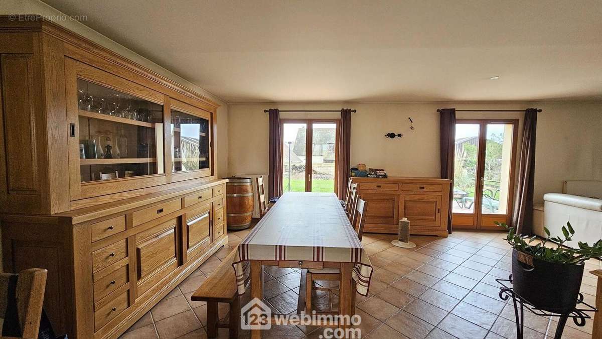 Un espace salle à manger avec un accès direct sur la terrasse. - Maison à SOISY-SUR-ECOLE