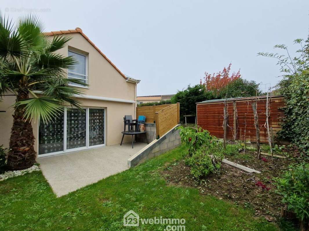 Façade arrière avec terrasse, abri de jardin. - Maison à LA ROCHE-SUR-YON