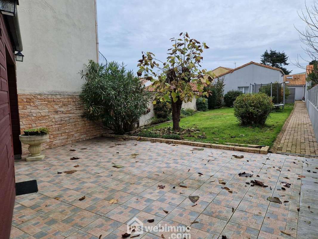 Terrasse maison principale avec jardin et garage au fond - Maison à LA ROCHE-SUR-YON