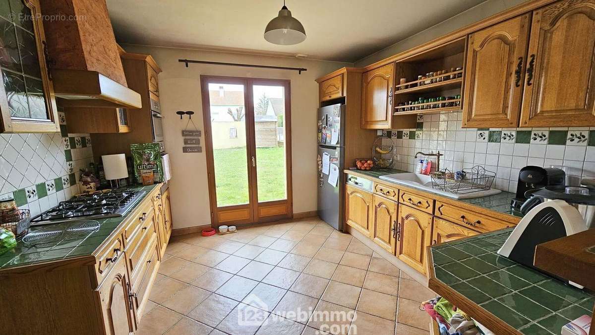 Une cuisine équipée de 12 m² et ouverte sur la salle à manger. - Maison à MILLY-LA-FORET