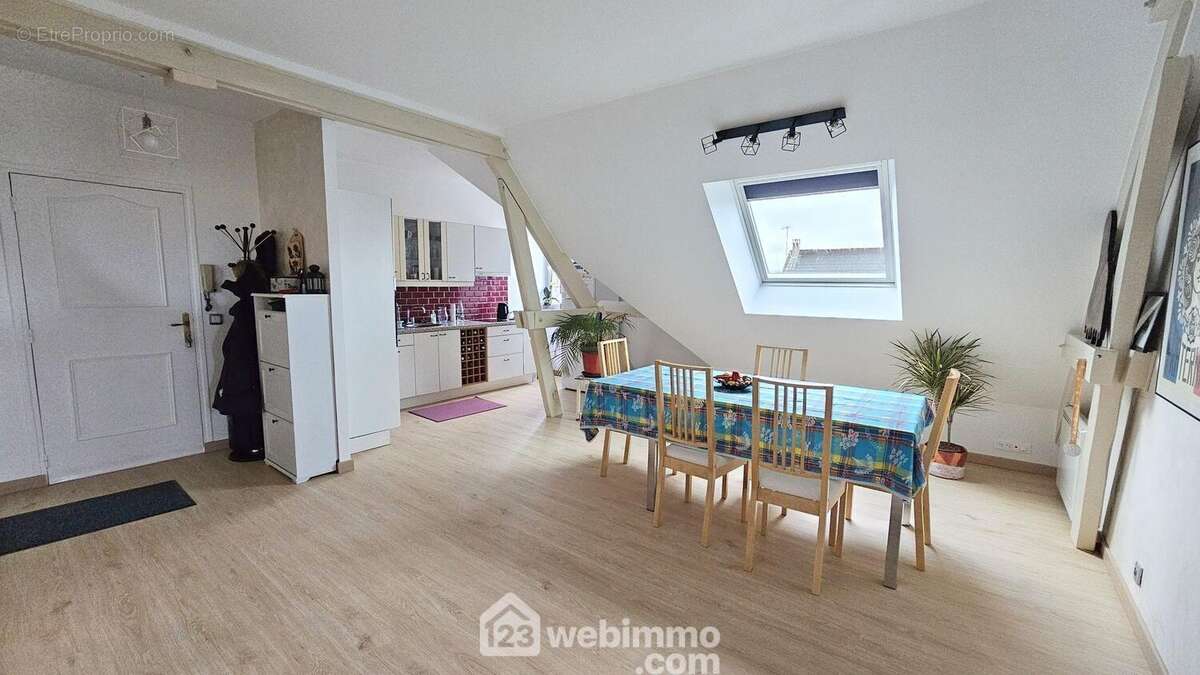 Un espace salle à manger avec un accès sur la cuisine. - Appartement à FONTAINEBLEAU